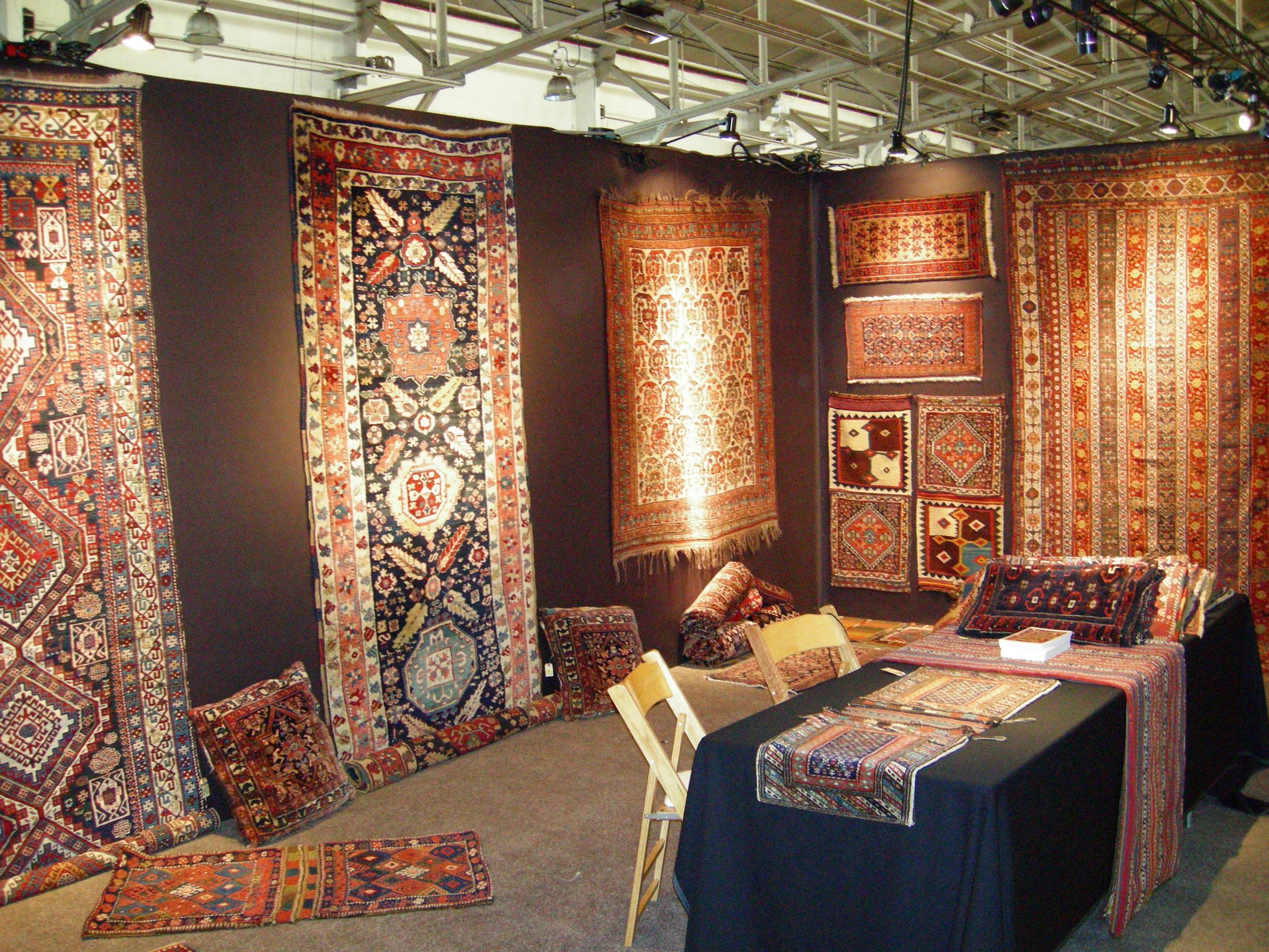 A trade-show booth curated with antique rugs and tribal textiles